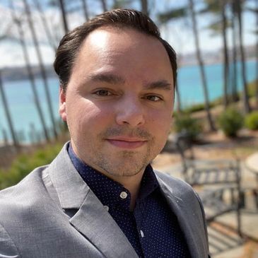 Man in a suit outdoors on a sunny day.