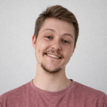 Smiling young man in a red t-shirt.