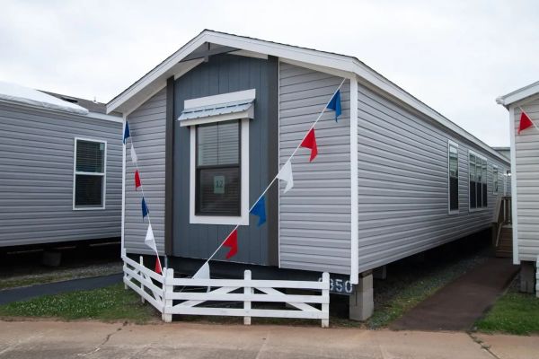 Gray mobile home with decorative pennant flags.