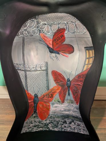 Red butterflies with numbers fly inside a barbed wire enclosure.