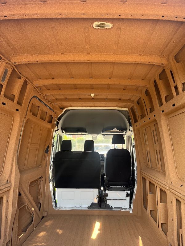 Empty van interior with brown insulation.