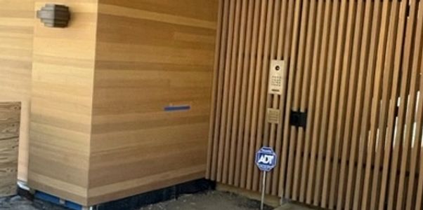 Modern wooden exterior with vertical slats and security system.