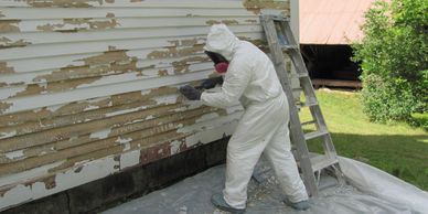 Matt Perkins scrapes clapboards at the North Wilmot Church, owned and maintained by the North Wilmot