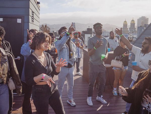 Group of people enjoying a rooftop party in the daylight.