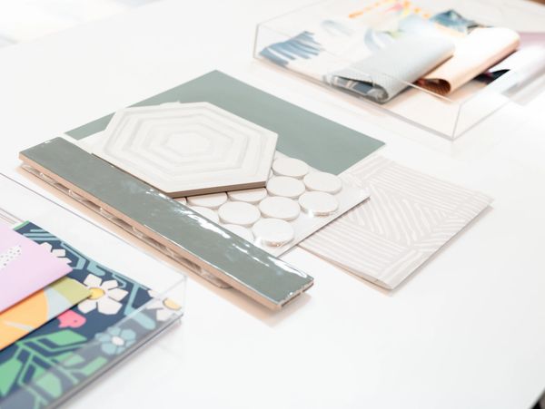 Various decorative tiles and samples arranged on a white surface.