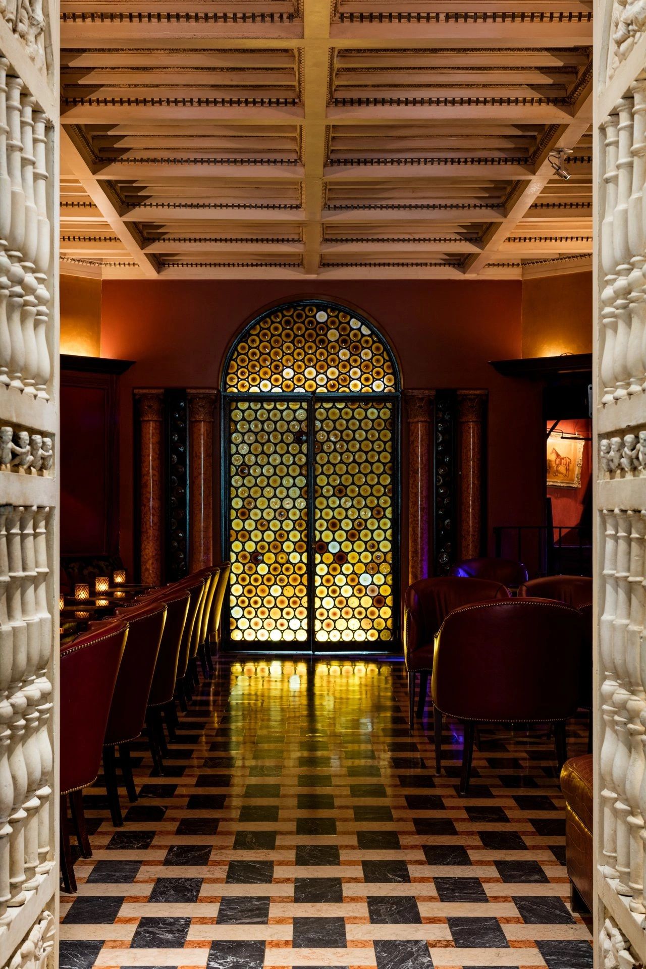 Luxurious room with stained glass door and patterned floor.