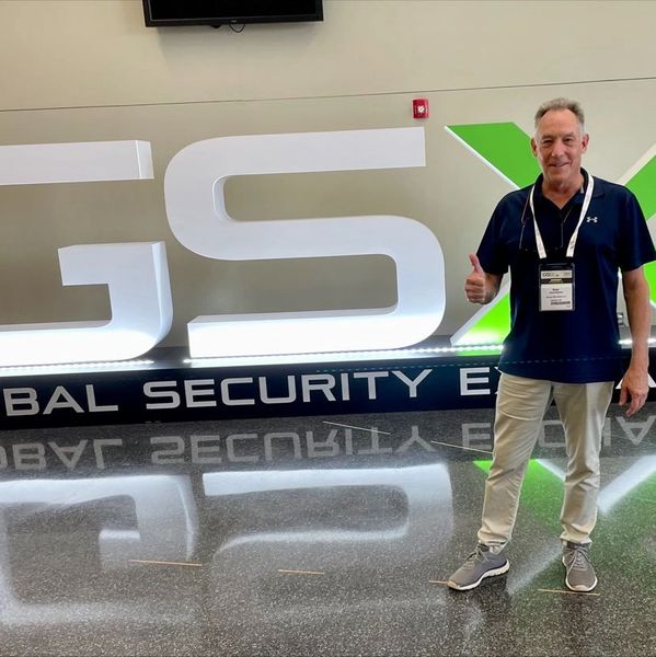 Man giving thumbs up in front of a large GSX sign.