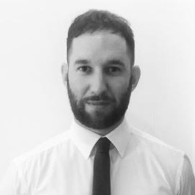Black and white portrait of a man in a dress shirt and tie.
