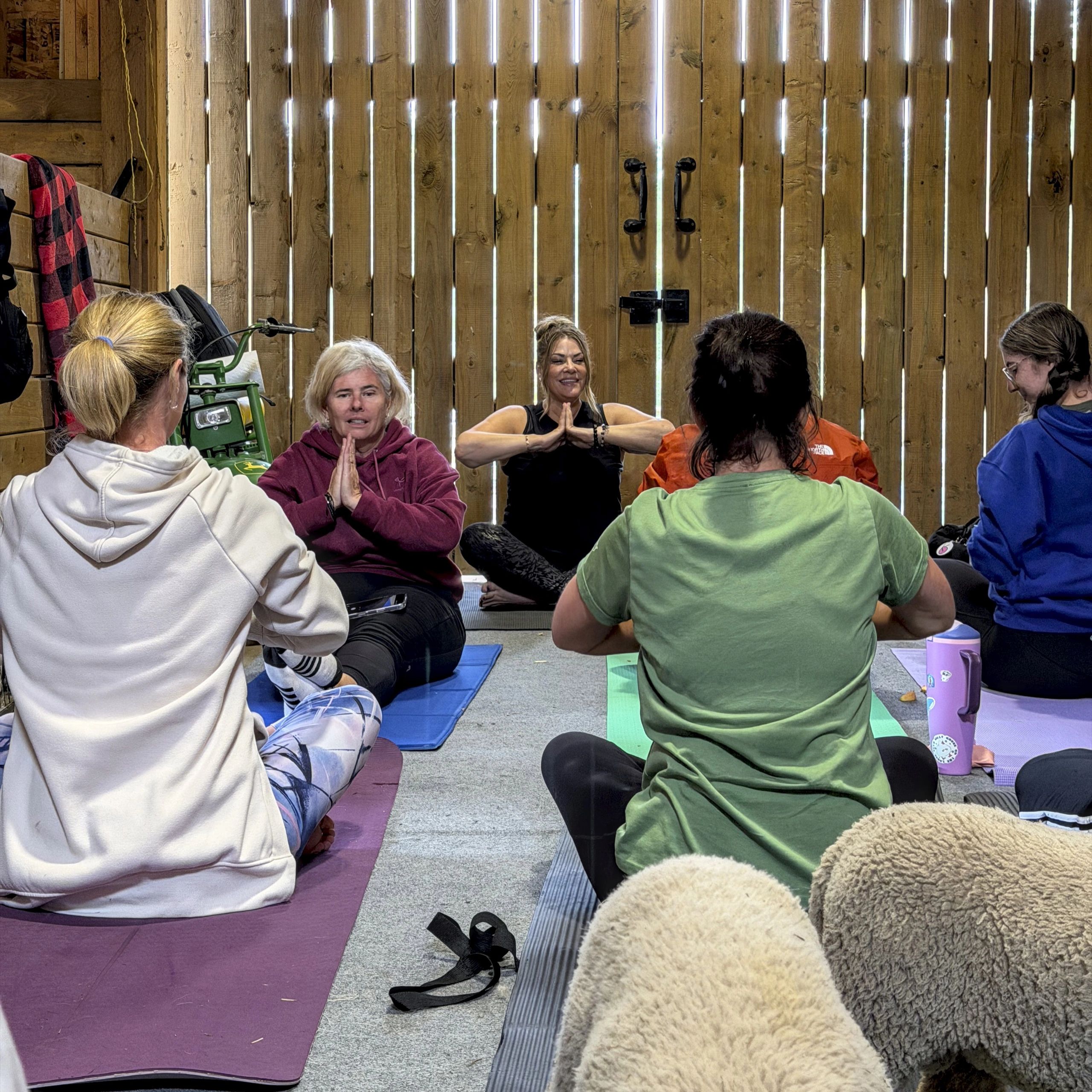 Group yoga session in a rustic barn.