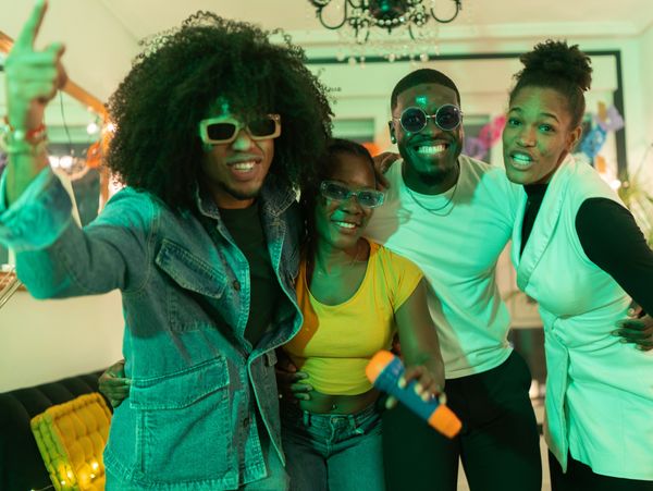 A group of friends smiling and enjoying a party indoors.