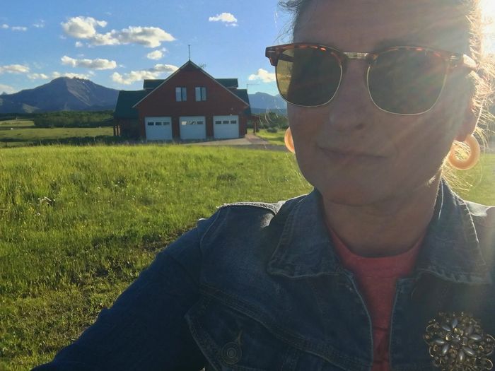selfie in front of the mountains and a farmhouse living a life of financial and time freedom and hap