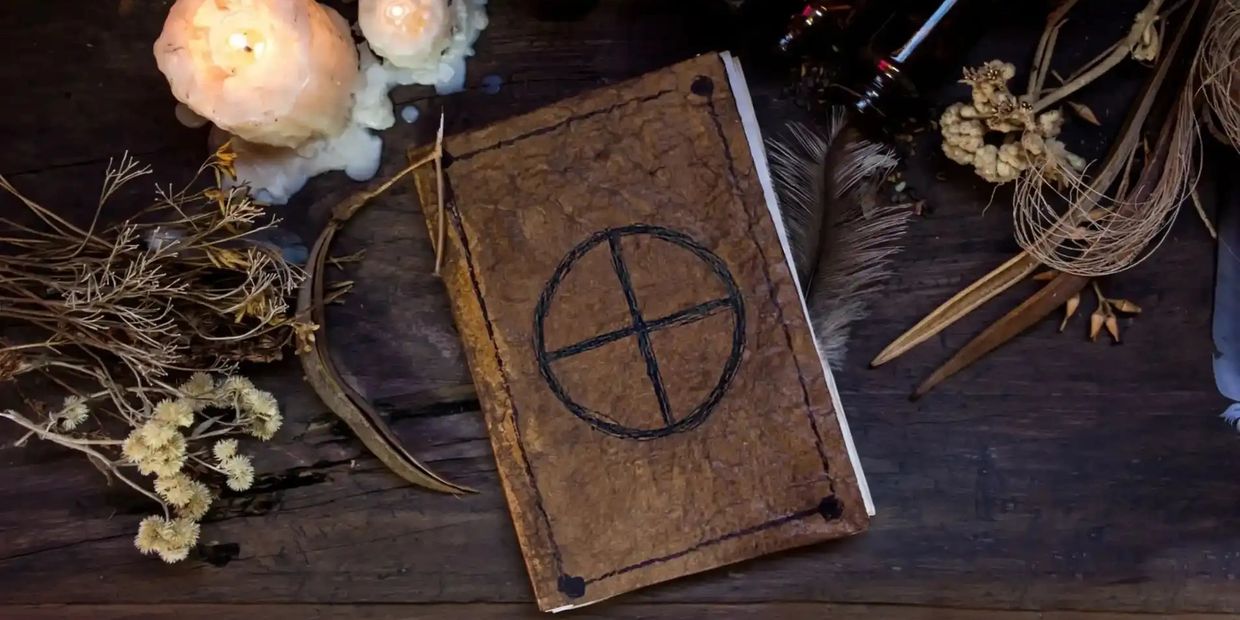 Altar for custom spell work and energy with book, herbs, and candles.