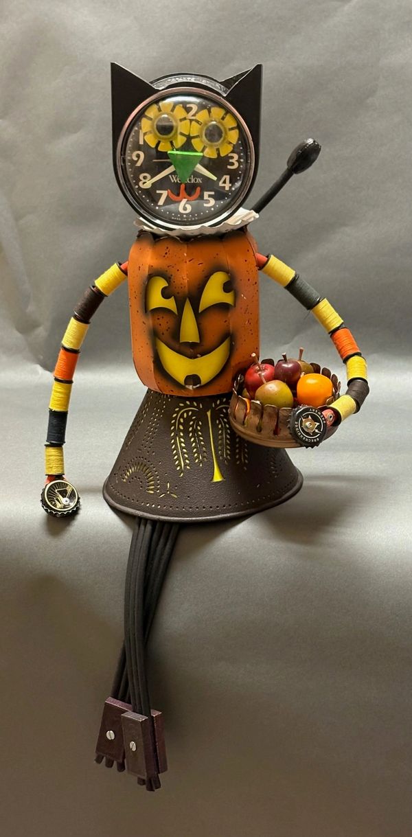 Whimsical clock figure with a pumpkin face holding a basket of fruit.