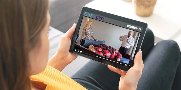Person watching an online occupational therapy training video on a tablet.
