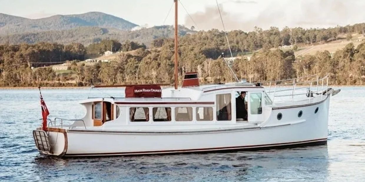The Experience on a Huon River Cruise - Huon River Cruises - Side of boat, hills in the background.