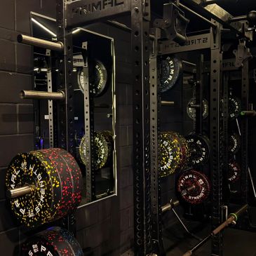 Weightlifting equipment with loaded barbell in a gym.