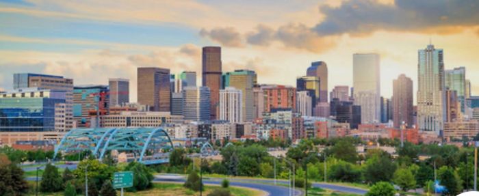 City skyline with modern buildings under a colorful sky.