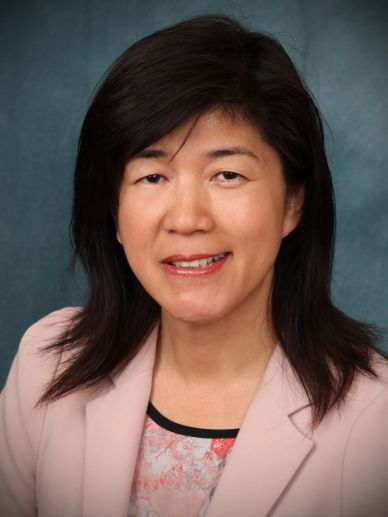 Professional headshot of a woman with dark hair.
