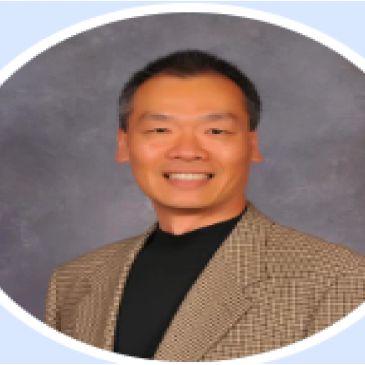 Man smiling in a checkered blazer.