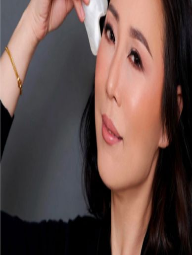 Woman using a facial massage device.