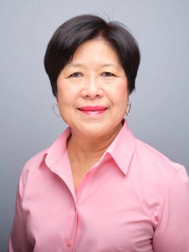 Smiling woman in pink shirt with short hair.