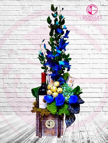 Wood vase with Cabernet wine, chocolates  and flower mixed with blue orchids, roses and hydrangea