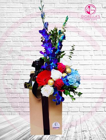Wine cellar with Cabernet wine, chocolates and  flower mixed with 
blue orchids, roses and hydrangea