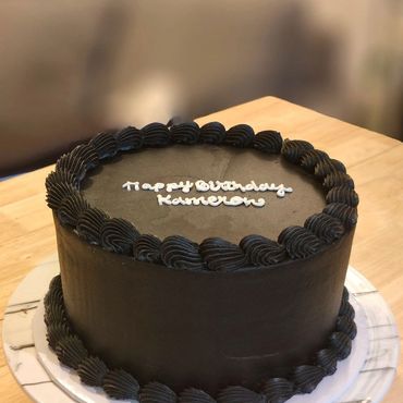 Chocolate birthday cake with 'Happy Birthday Kameron' written.