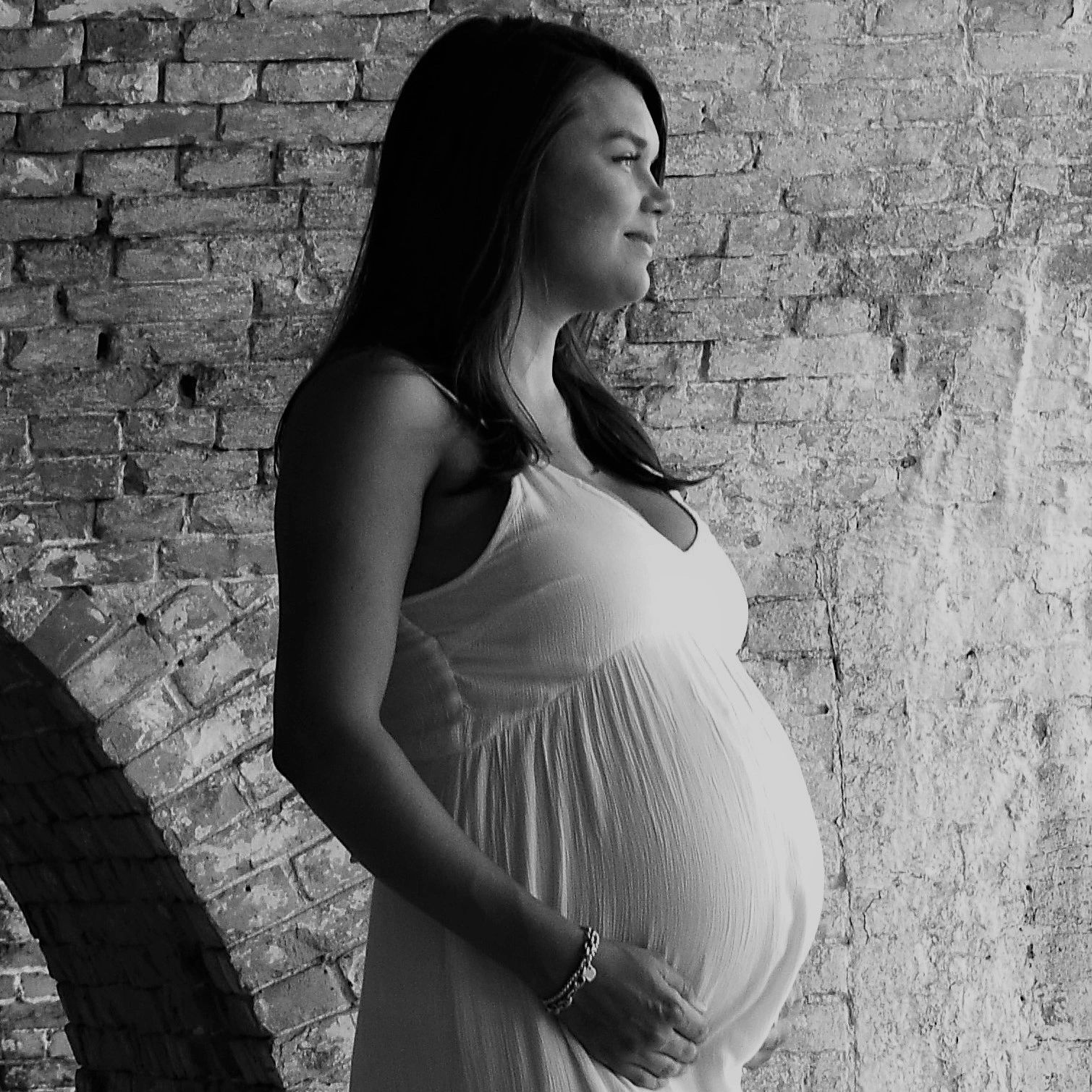 Happy pregnant mother cradling her baby bump