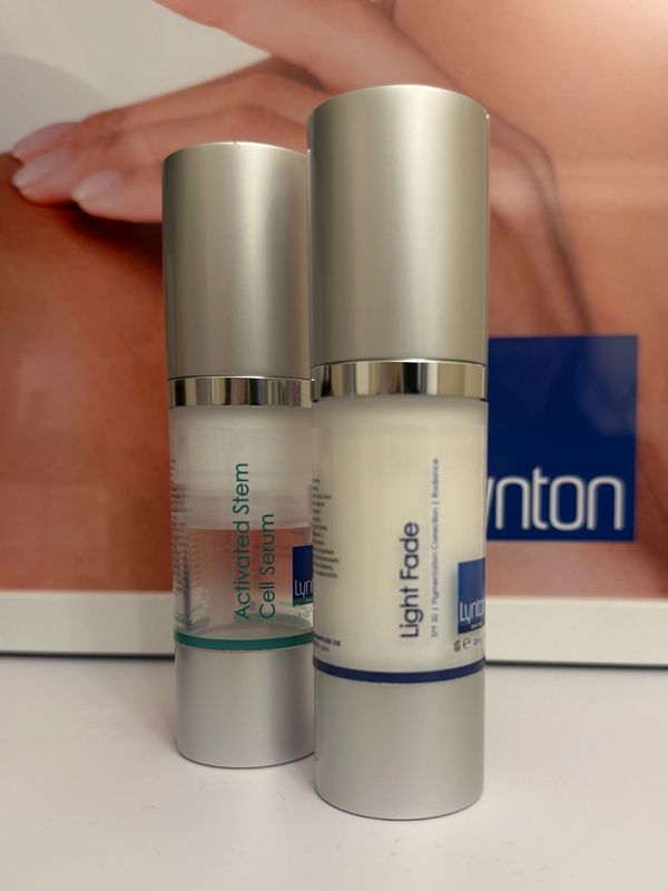 Two skincare serums with silver caps on a white surface.