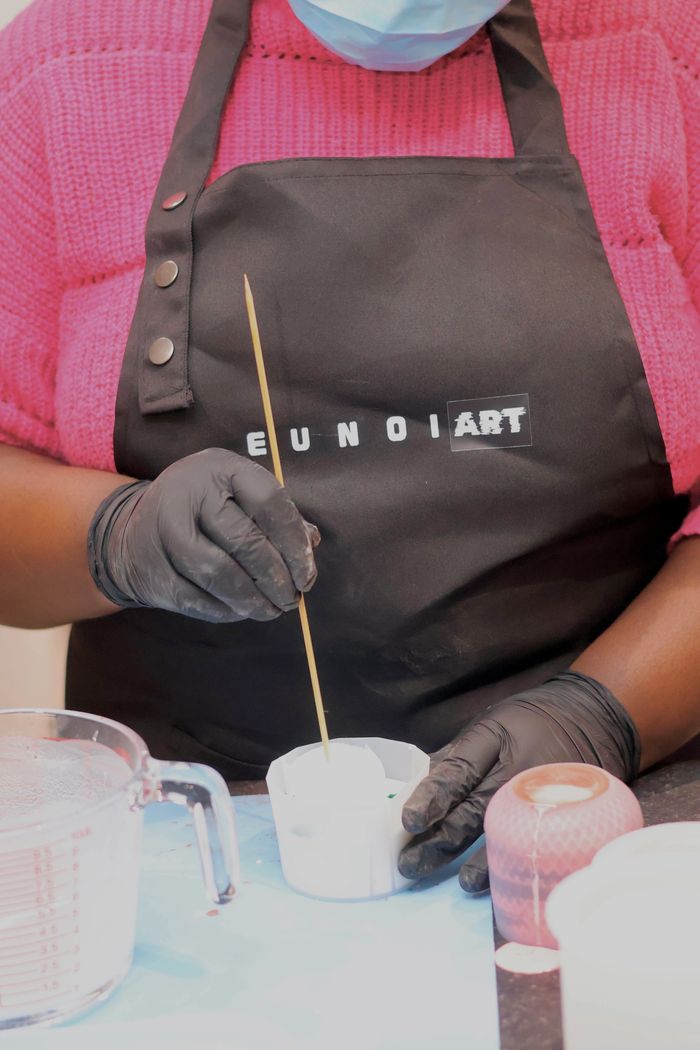 Stack of books next to pencils in a holder and a camera.