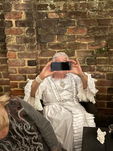 Person in vintage white dress taking a selfie.