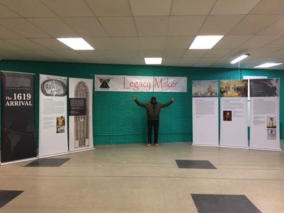 Kyendamina Mukeba stands under the RKC Banner with the 1619 Traveling Exhibit - Week one         