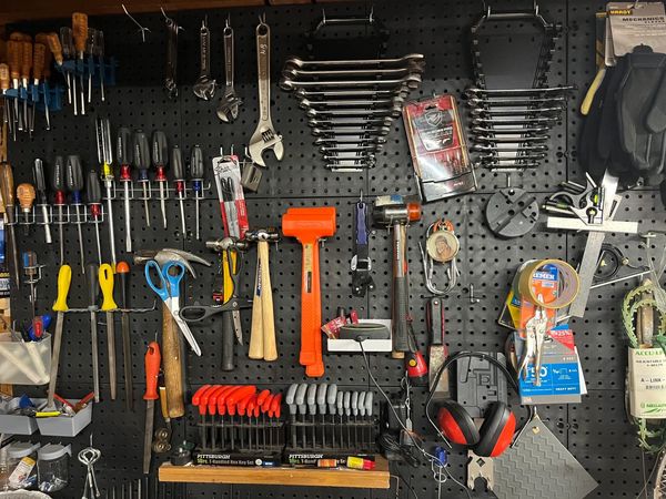 Organized pegboard with various hand tools and accessories.