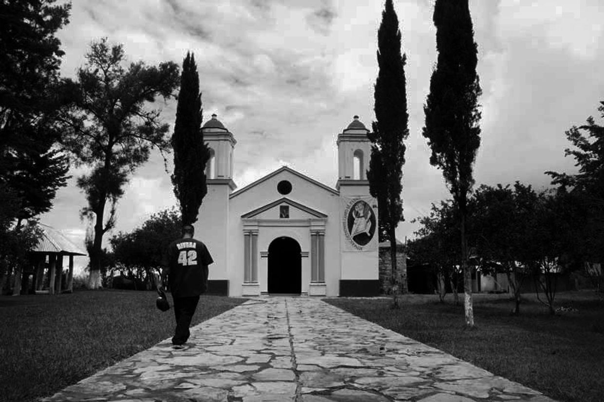 Una persona camina hacia una iglesia con arquitectura sencilla.