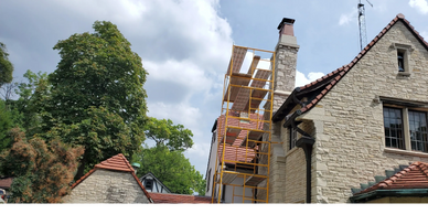 Stone chimney with scaffolding, masonry work