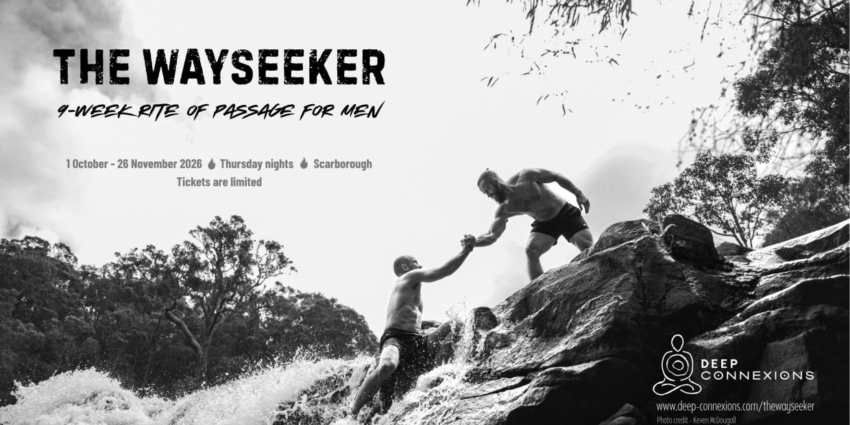 Two men climbing rocks with one helping the other.