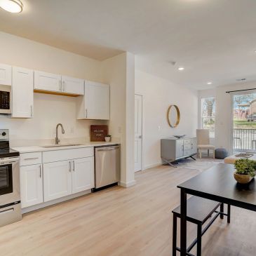Modern kitchen and living area with light wood flooring.