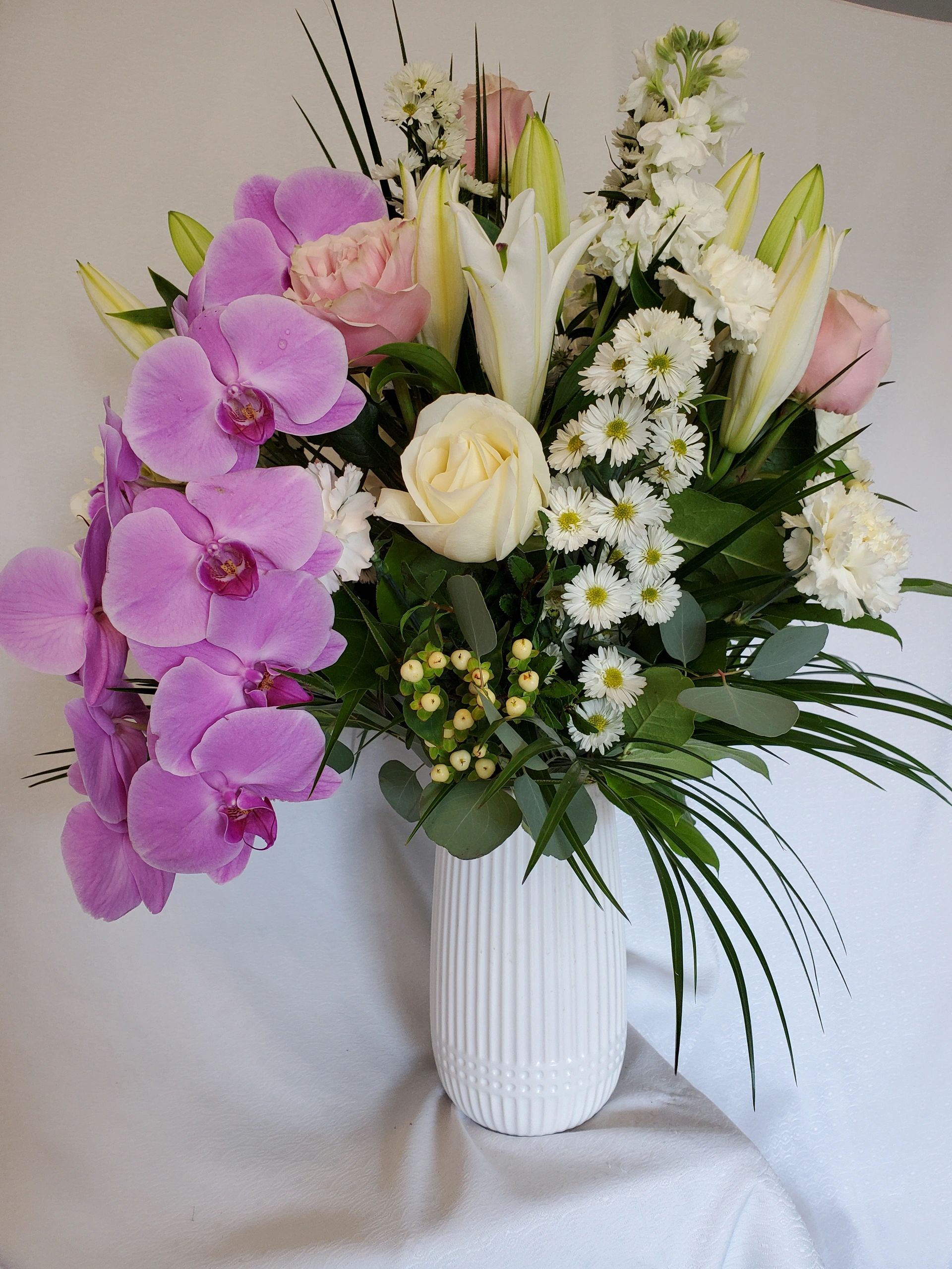 Elegant floral arrangement in white ceramic vase.