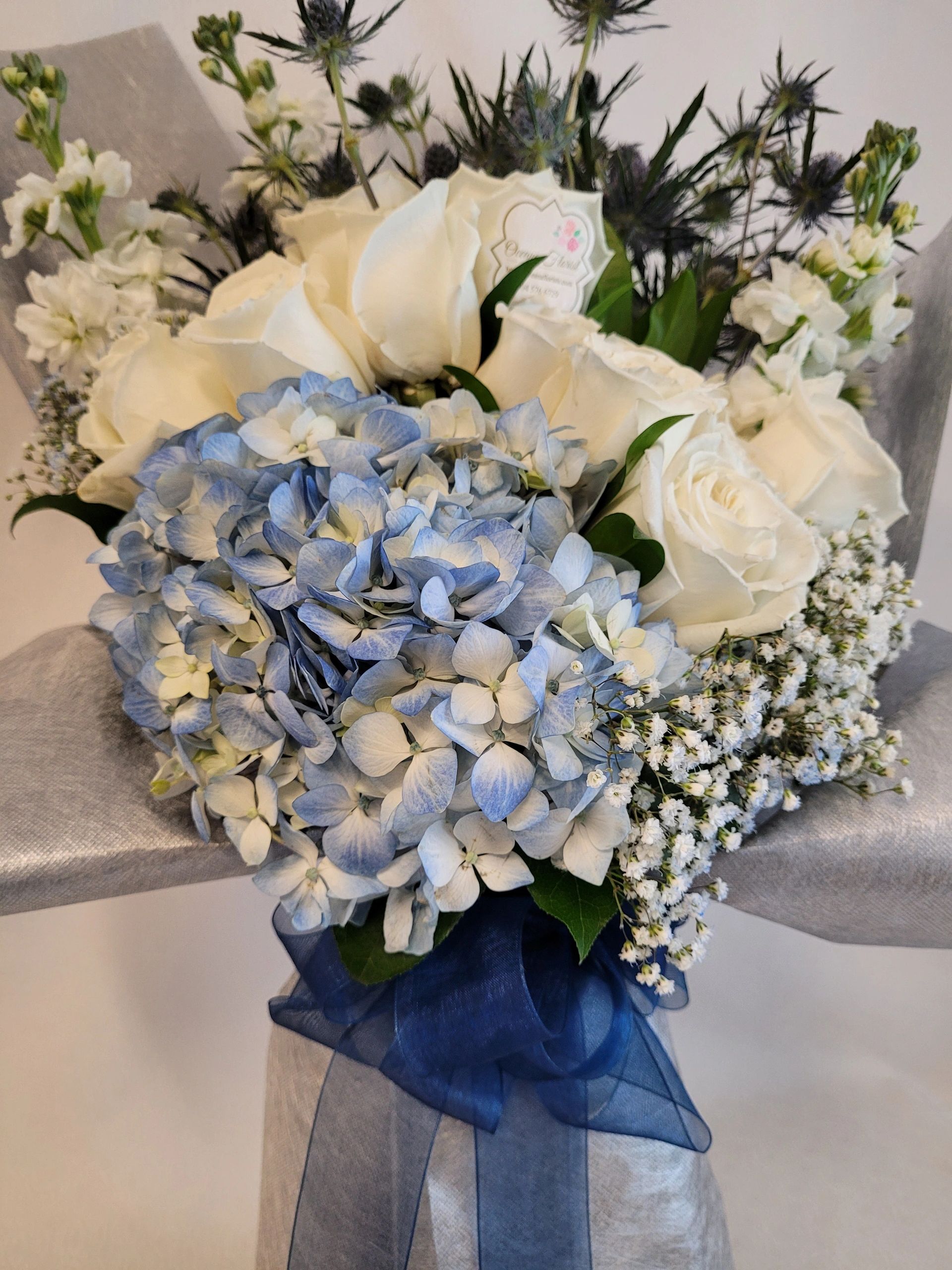 Blue hydrangia and white roses flower arrangement.