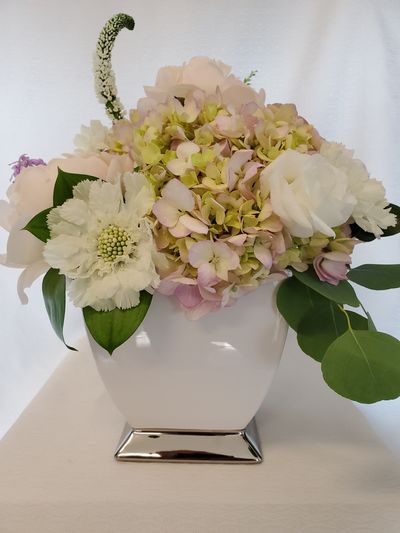 Elegant floral arrangement in a white ceramic vase.