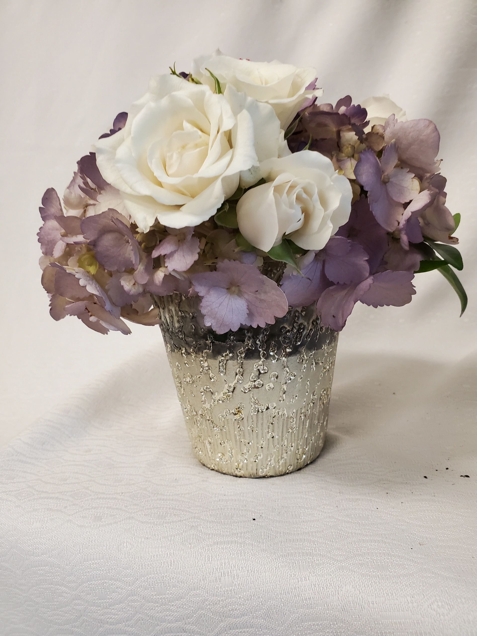 White rose and hydrangeas in an elegant vase.