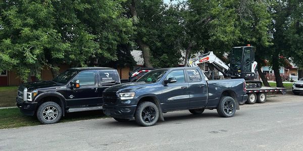 two Rencore company trucks, one loaded with an excavator 