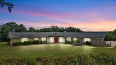 Single-story house during sunset with glowing windows.