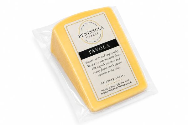 A block of Peninsula Cheese Tavola in clear packaging with a descriptive label.