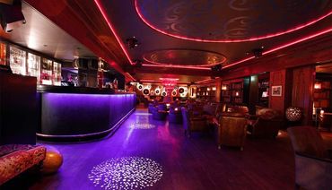 Luxurious bar lighting design with vibrant LED accents and ornate decor.