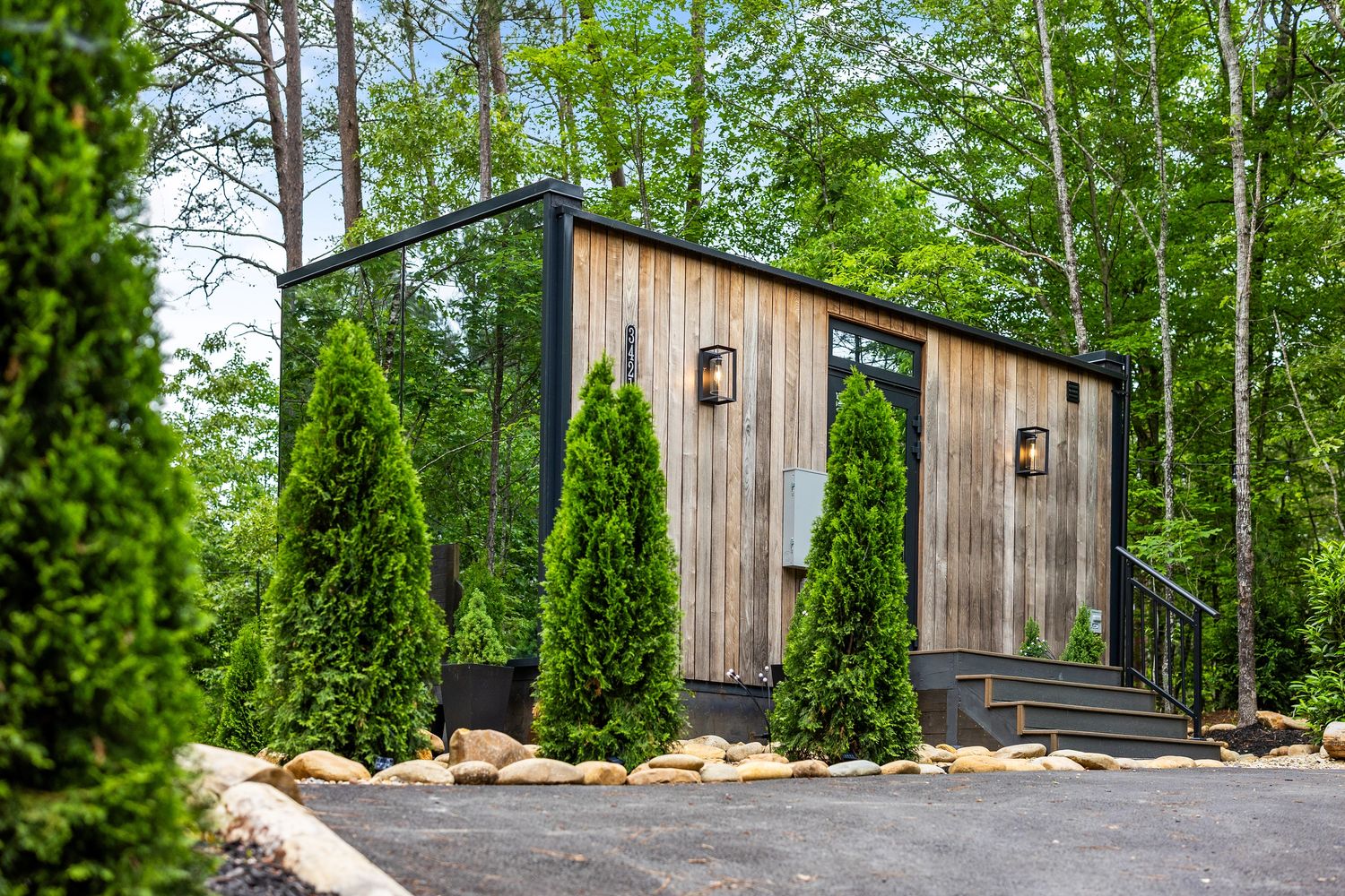 Incredible mirror house cabin in the Smoky Mountains Tennessee surounded by lush greenery.