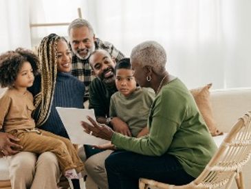Family gathered as grandmother reads a story to children.