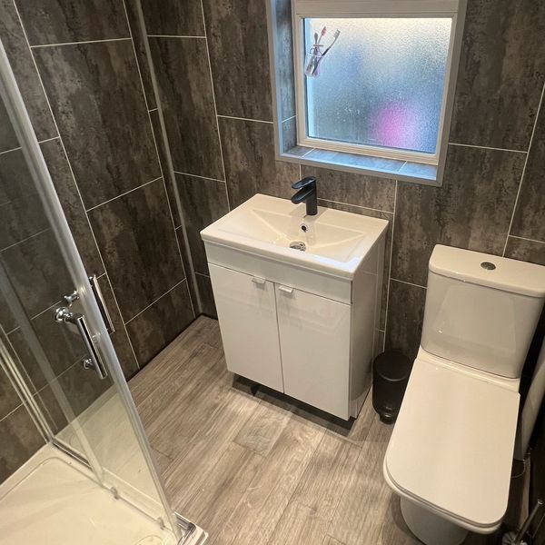Modern bathroom with white sink and toilet.