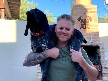 Arizona quail hunting guide with german shorthaired pointer on shoulders.